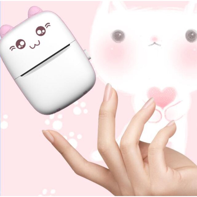 Cute white device with cartoon face held by a hand against a pink background