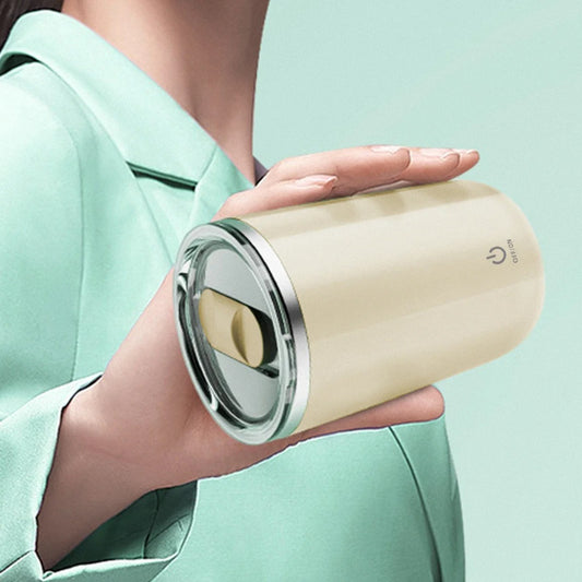 Person holding a beige tumbler with a silver lid against a light green background